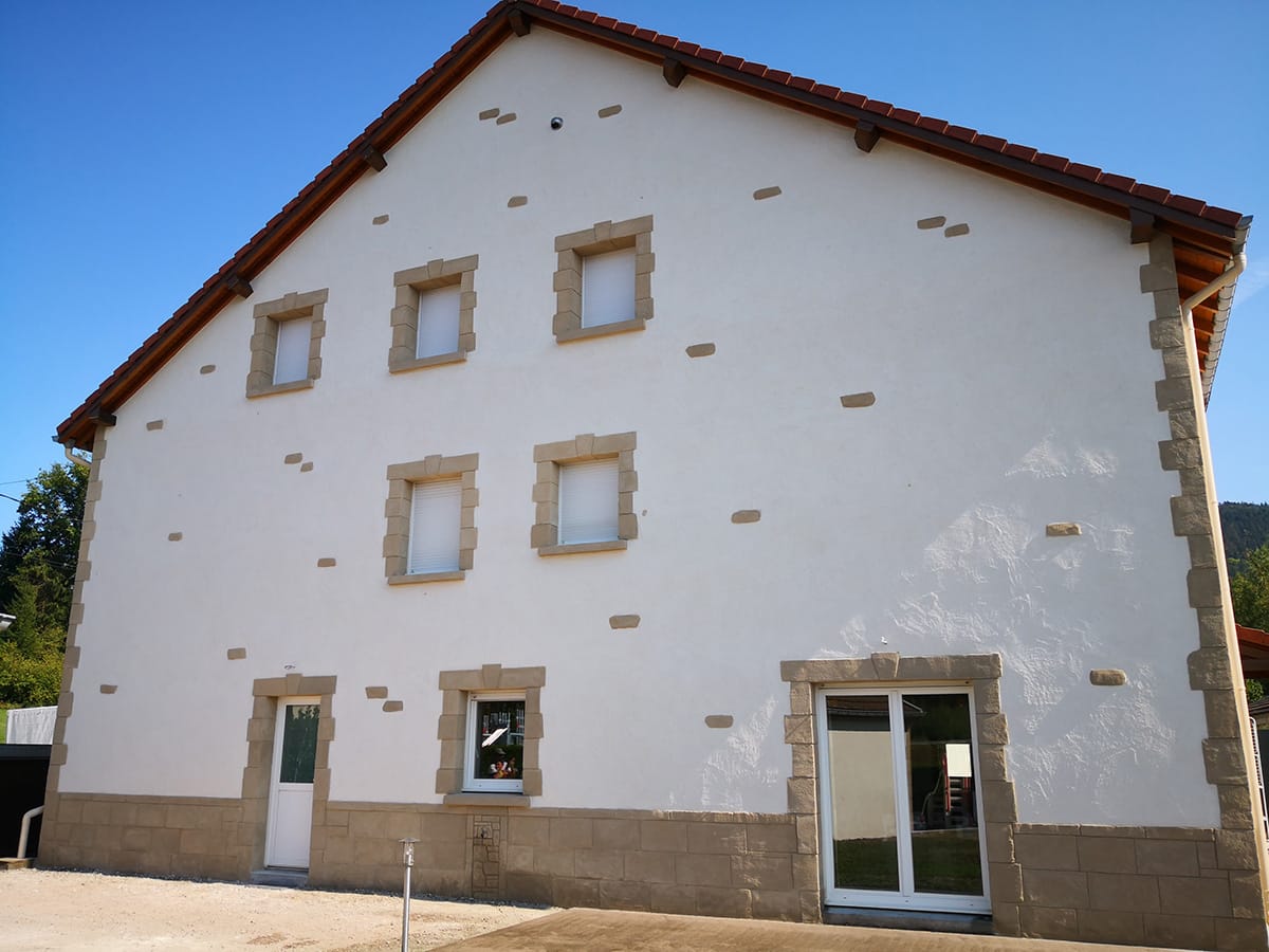 Façade de maison en pierre recouverte d’un enduit traditionnel à la chaux aérienne