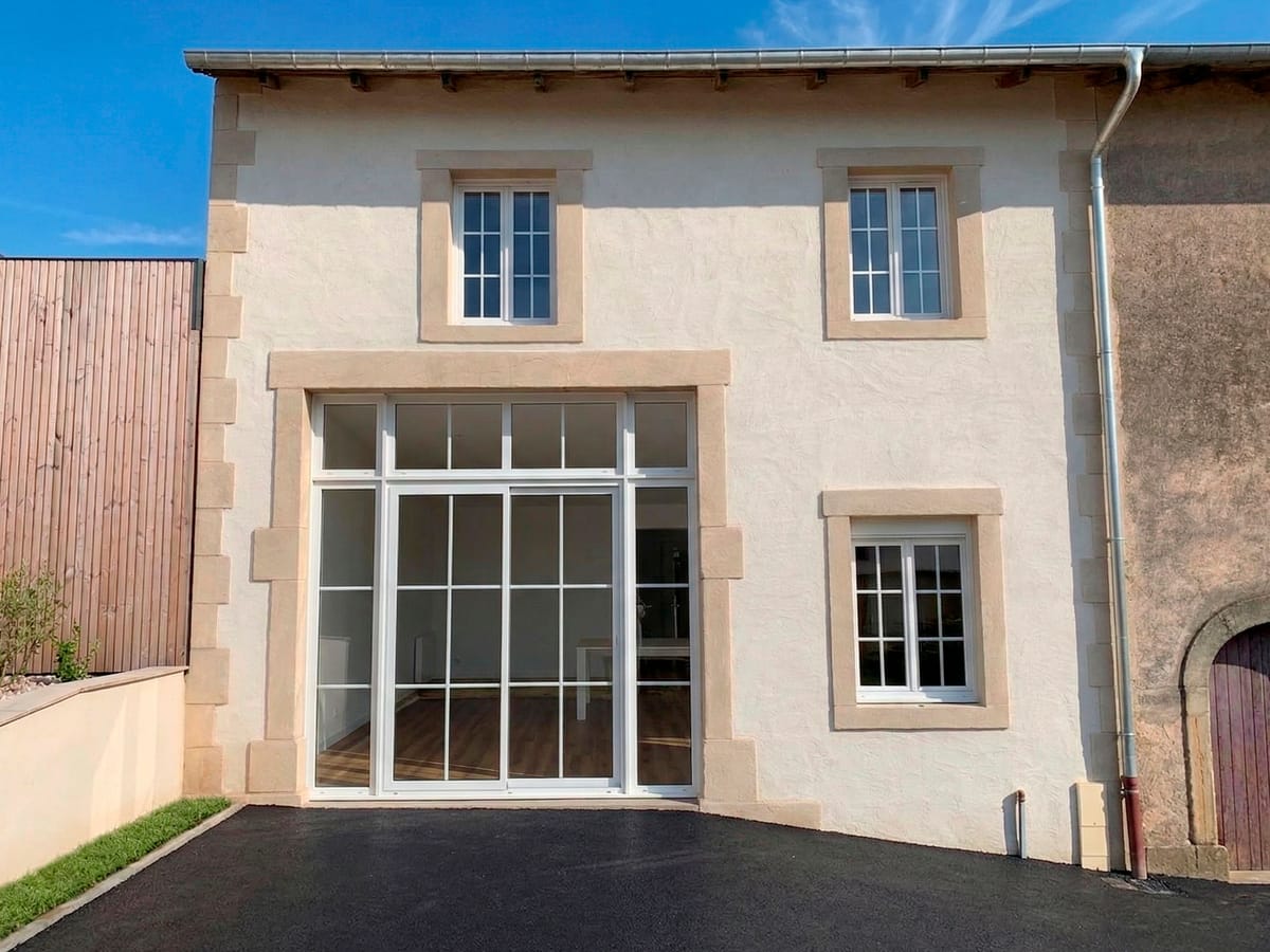 Façade rénovée en enduit à la chaux avec encadrements en pierre de taille
