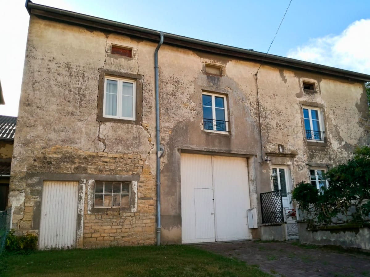 Façade de ferme à l’enduit ancien dégradé avant ravalement