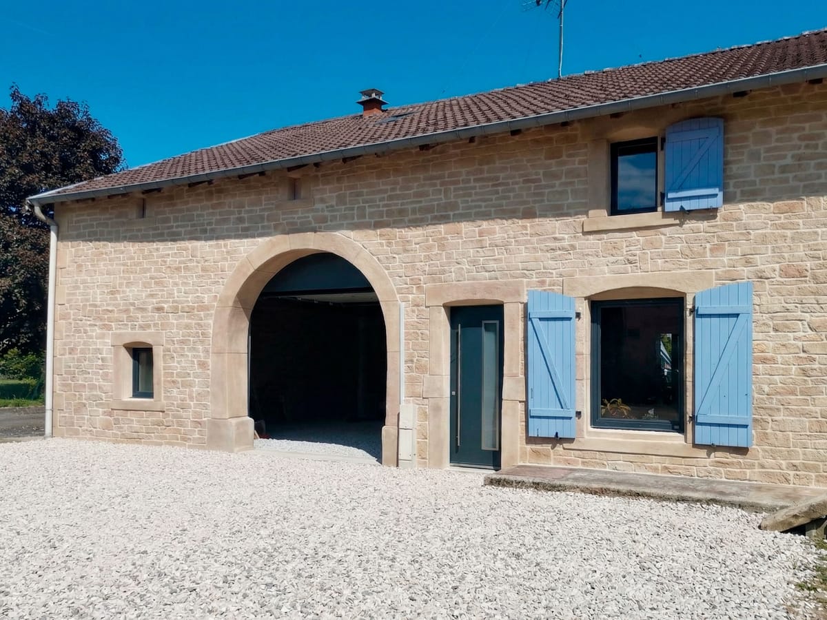 Grange restaurée avec joints à la chaux et arche mise en valeur
