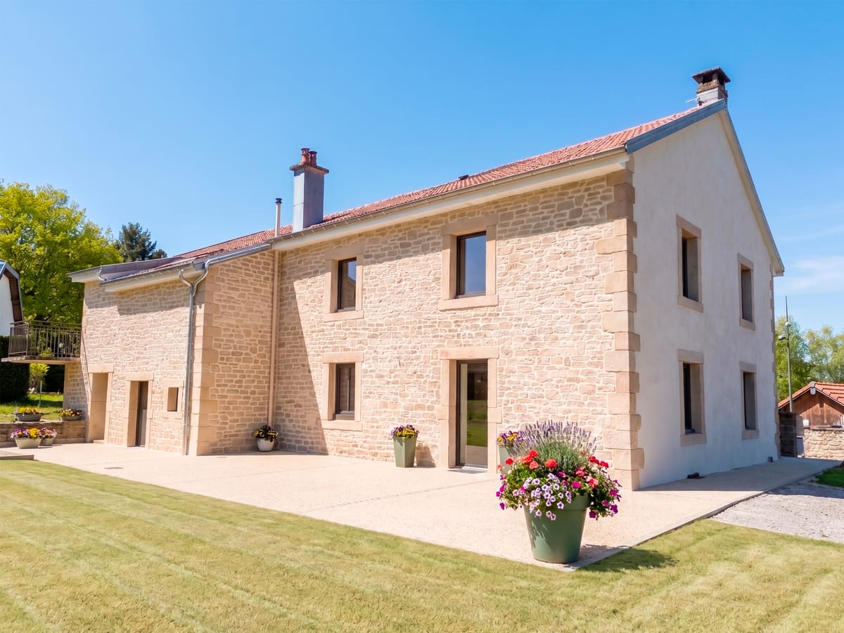 Maison en imitation pierre apparente avec pignon en enduit à la chaux