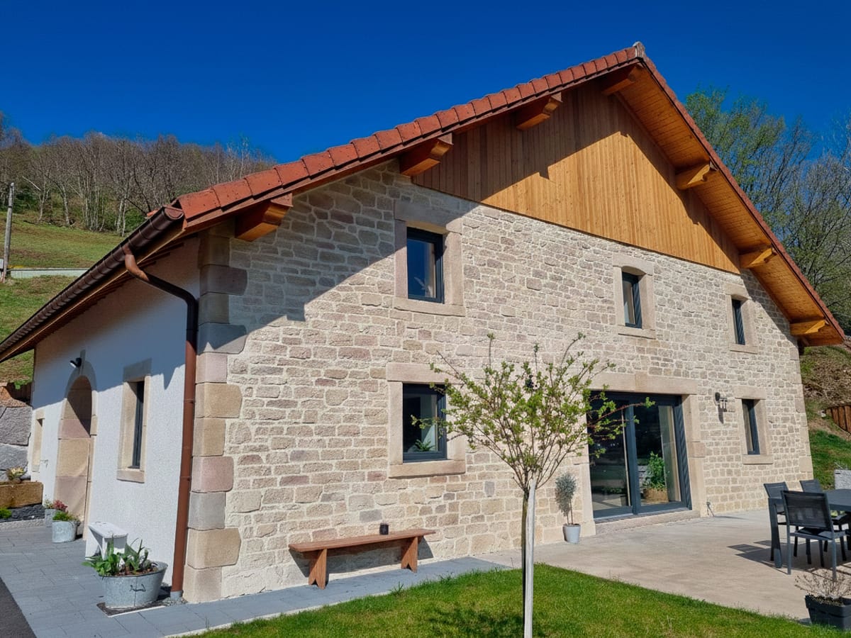 Maison en imitation pierre jointée avec large baie vitrée