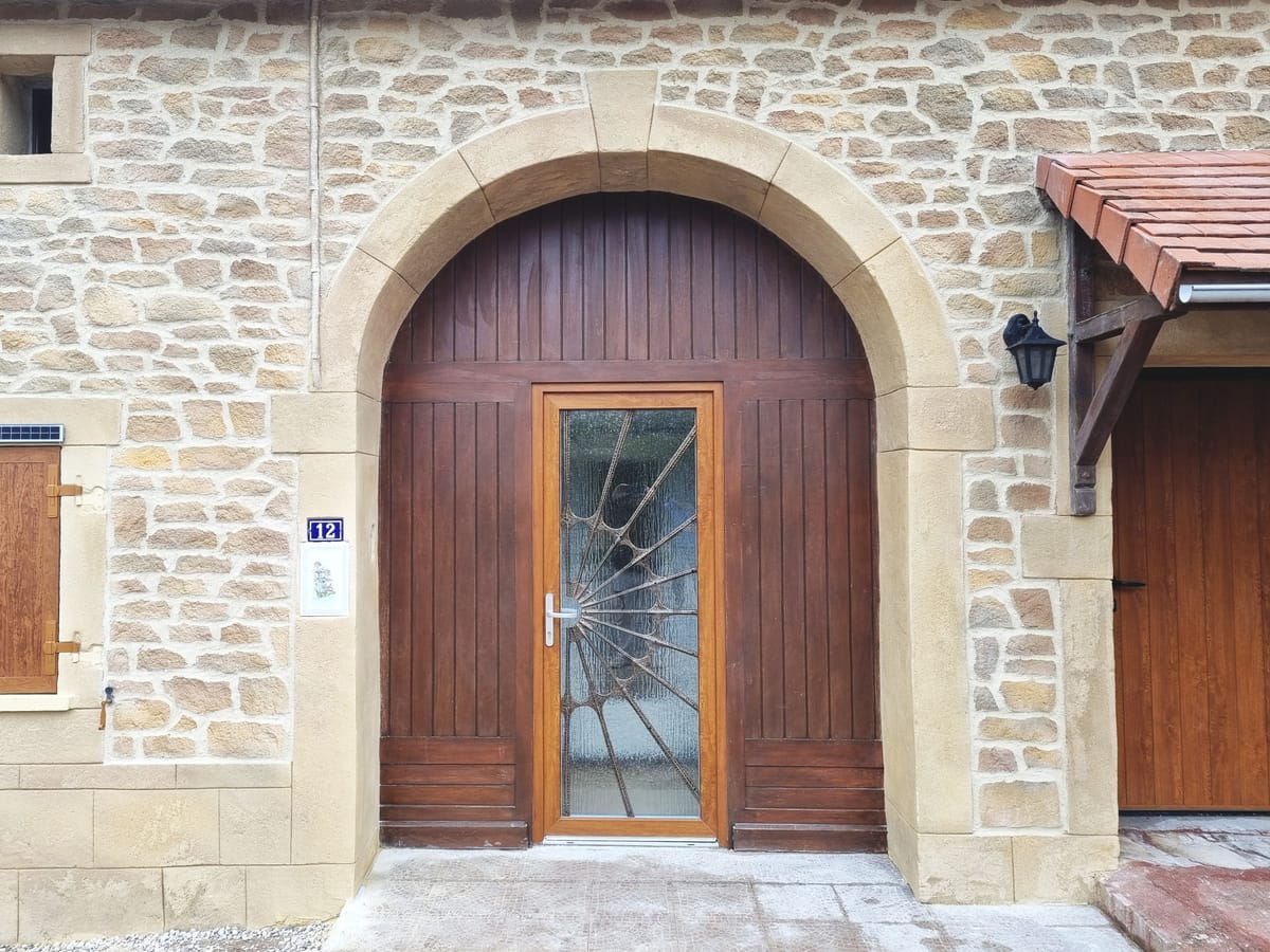 Porte d’entrée cintrée avec encadrement en imitation pierre de taille