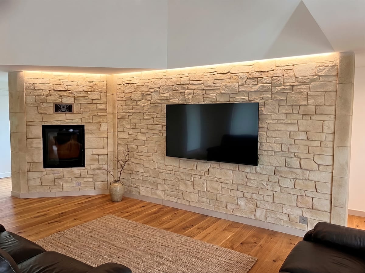 Mur de salon en imitation pierre sèche beige avec habillage TV intégré