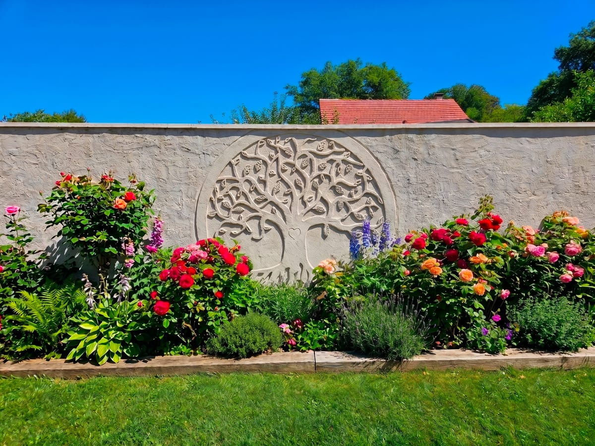 Fresque sculptée en bas-relief représentant un arbre de vie sur un mur de jardin
