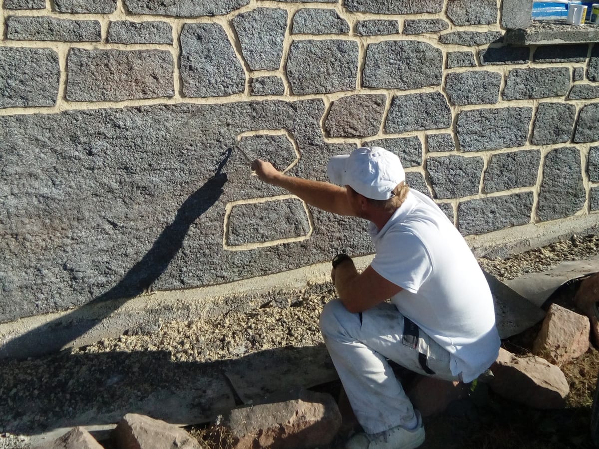 Sculpture à la main d’une imitation pierre de granit sur un mur de soutènement