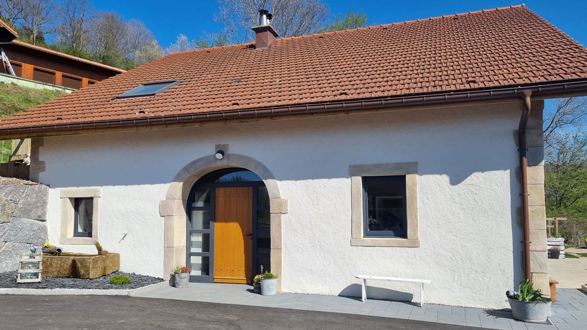 Façade traditionnelle rénovée avec enduit à la chaux et imitation pierre dans les Vosges par Commedelapierre